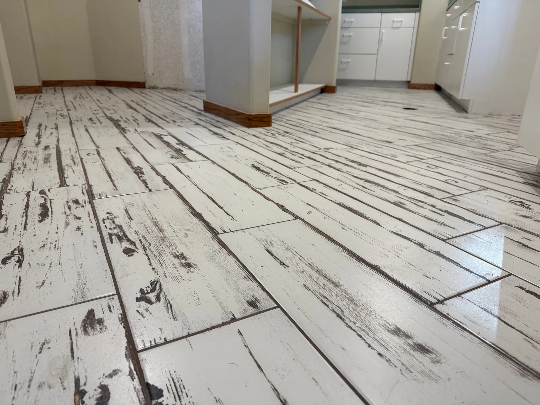 Wood-look plank tile floor laid in a staggered pattern in a kitchen